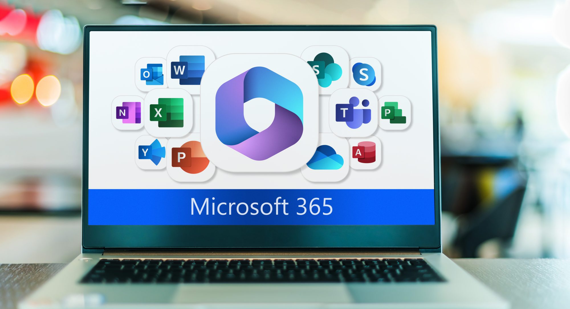 A laptop screen displaying various Microsoft 365 app icons, including Outlook, Word, Excel, PowerPoint, OneNote, SharePoint, Teams, and others surrounding a central Windows 365 logo.