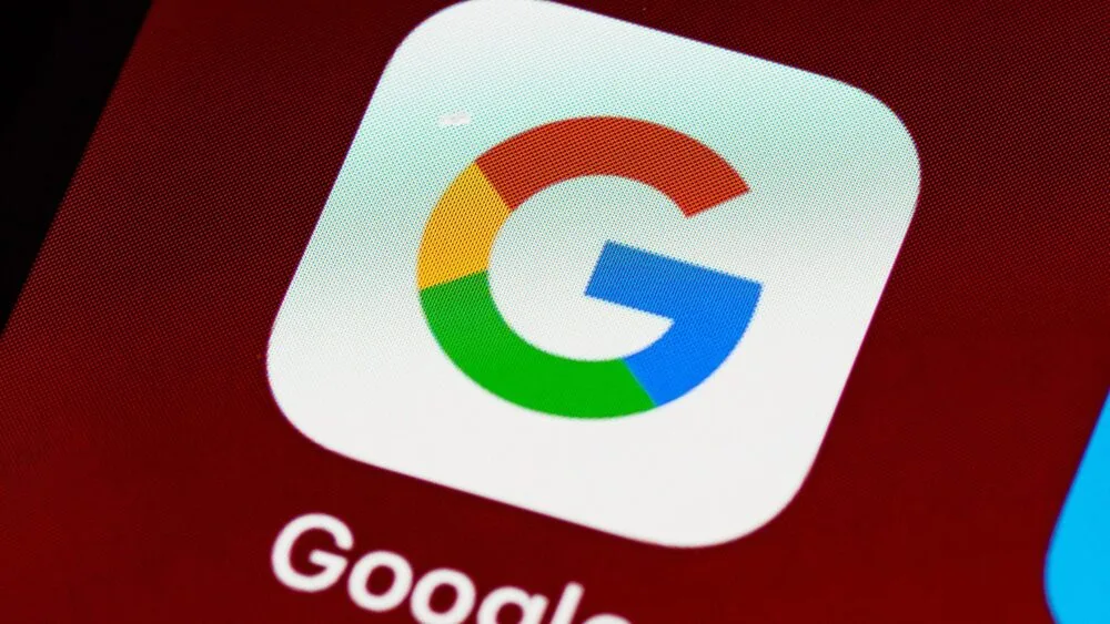 Close-up of the Google app icon on a smartphone screen, featuring the letter "G" with blue, red, yellow, and green segments against a white background.