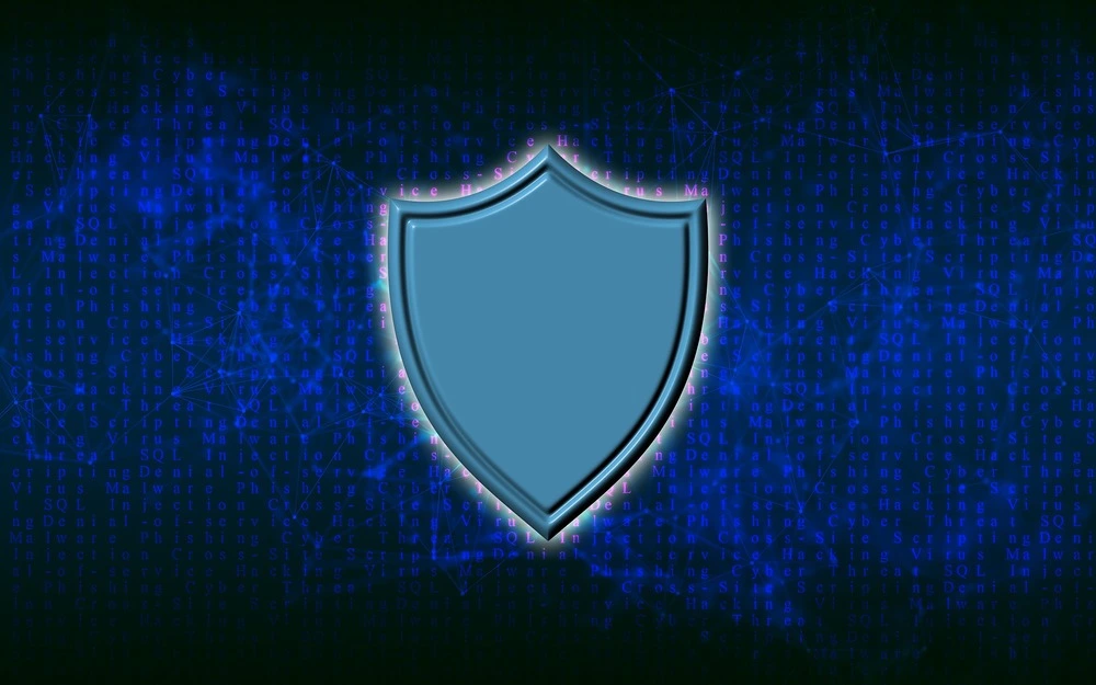 A blue shield icon is centered against a dark background filled with lines of code and network patterns, representing cybersecurity and data protection.