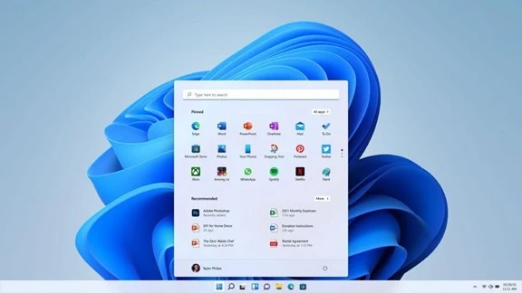 A computer desktop displays the Windows 11 start menu with various app icons on a blue abstract background.