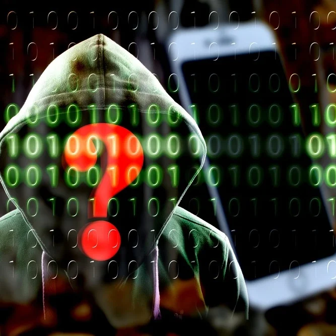 A hooded figure with a red question mark on their face stands in front of a background filled with green binary code.