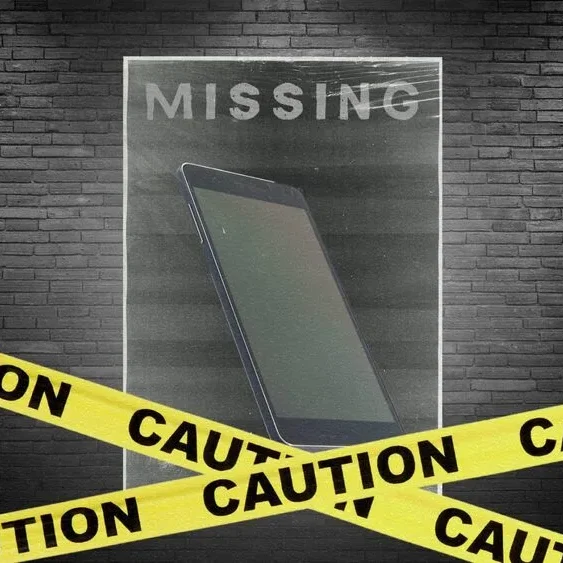 A missing poster with a faint image of a smartphone is taped to a dark brick wall.