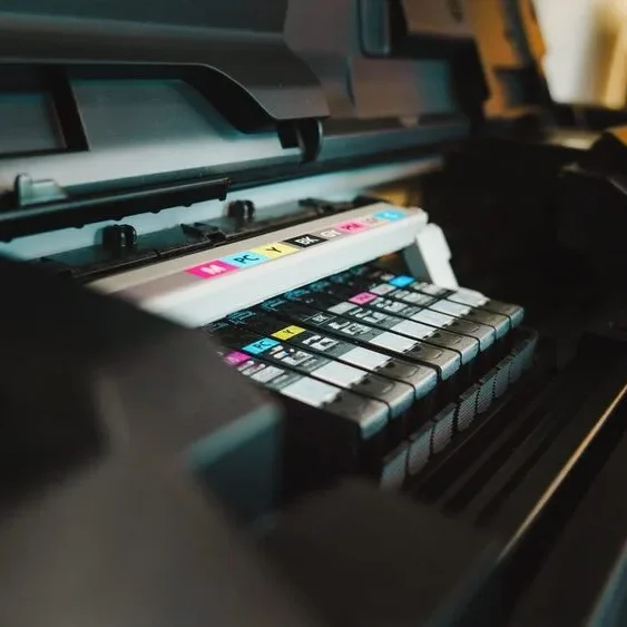 Close-up of a printer with its lid open, revealing multiple ink cartridges inside.